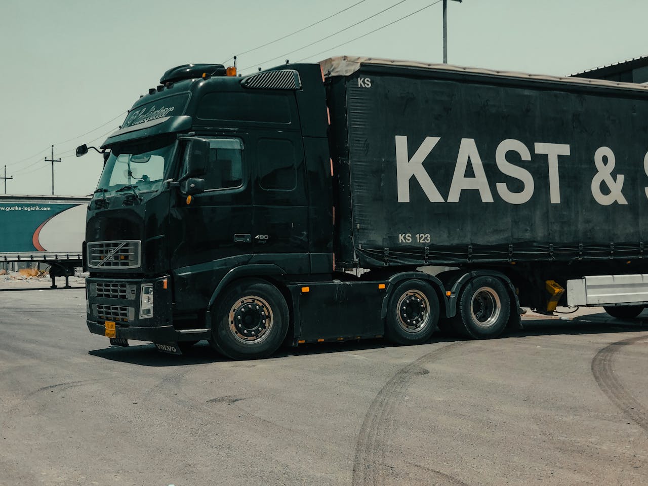 services-01 A large industrial truck parked in an urban setting, showcasing transportation industry visuals.