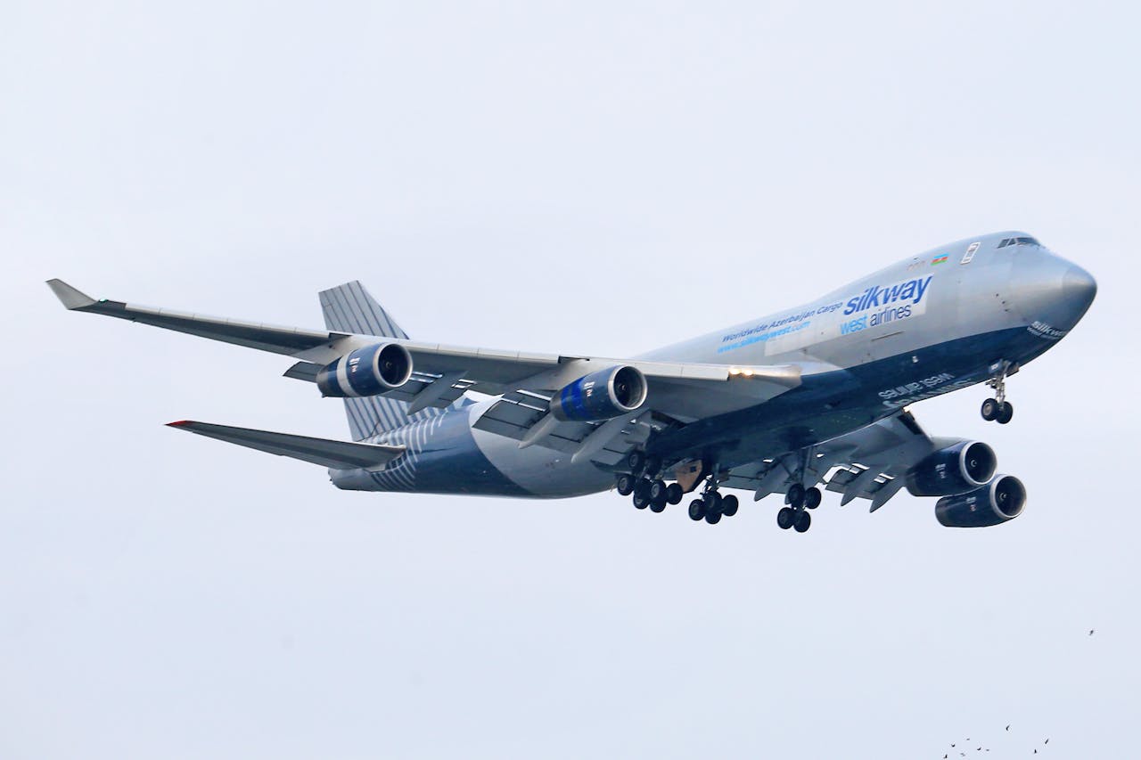 Silk Way West Airlines Boeing 747 flying against a clear sky.